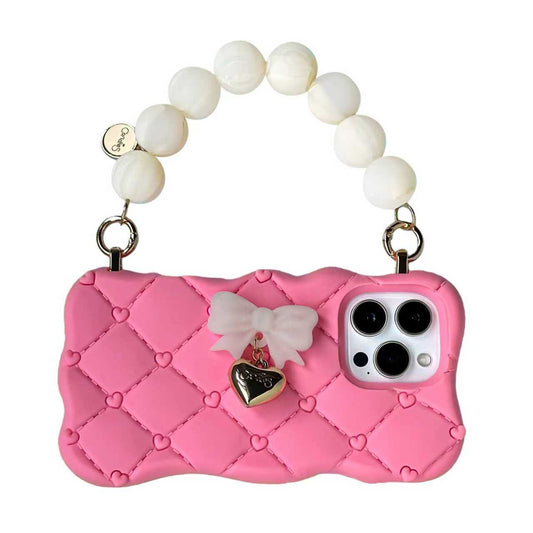 Pink phone case with bow and heart charm on a white background